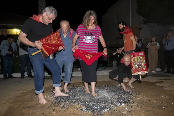 Lagadas, Yunanistan 23 Mayıs 2023: Anastenaria ayini sırasında inananlar, inancın, arındırmanın ve geleneğin sembolü olarak dini simgeler ve kırmızı bezlerle yanan kömürlerin üzerinde yalınayak yürürler.