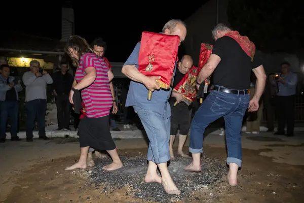 Lagadas, Yunanistan 23 Mayıs 2023: Anastenaria ayini sırasında inananlar, inancın, arındırmanın ve geleneğin sembolü olarak dini simgeler ve kırmızı bezlerle yanan kömürlerin üzerinde yalınayak yürürler.