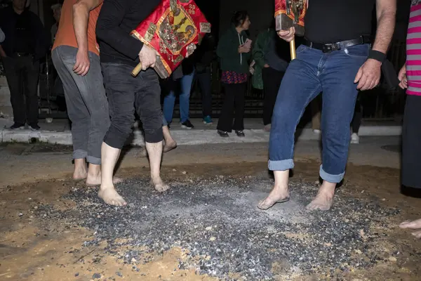 Lagadas, Yunanistan 23 Mayıs 2023: Anastenaria ayini sırasında inananlar, inancın, arındırmanın ve geleneğin sembolü olarak dini simgeler ve kırmızı bezlerle yanan kömürlerin üzerinde yalınayak yürürler.