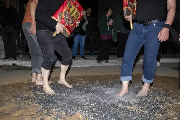 Lagadas, Yunanistan 23 Mayıs 2023: Anastenaria ayini sırasında inananlar, inancın, arındırmanın ve geleneğin sembolü olarak dini simgeler ve kırmızı bezlerle yanan kömürlerin üzerinde yalınayak yürürler.