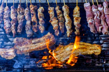 Şiş dolu bir ızgara ve ateşte pişmiş domuz eti. Et kahverengiler gibi duman yükselir, sahne geleneksel barbeküyü gösterir. Greek Souvlaki