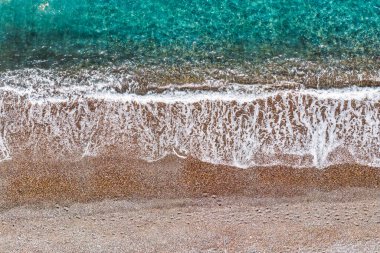   Çakıl taşlı sahil manzarası ve yumuşak dalgalı turkuaz deniz, bir yaz günü bu kıyı köyünün dingin güzelliğini yakalıyor, Agia Anna, Evia, Yunanistan