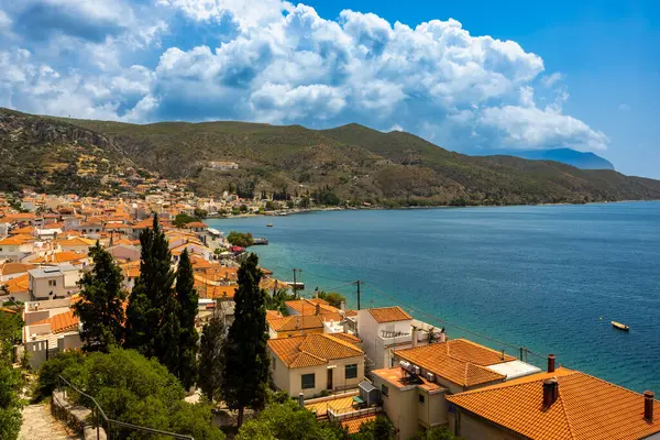 Limni, Evia, Yunanistan sahil köyü. Çakıl taşlı plajları, sakin mavi suları, geleneksel evleri ve manzaralı sahil şeridi boyunca sakin bir yaz havası var.