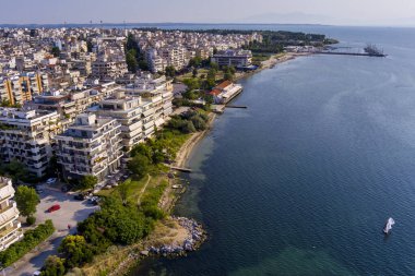Yunanistan 'ın doğusundaki Selanik' in hava manzarası, açık mavi gökyüzü altında kıyı kentsel mimarisi, deniz ufku ve sakin şehir manzarası sergileniyor