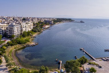 Yunanistan 'ın doğusundaki Selanik' in hava manzarası, açık mavi gökyüzü altında kıyı kentsel mimarisi, deniz ufku ve sakin şehir manzarası sergileniyor
