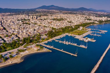 Selanik 'in batı kıyı şeridi ve Kalochori lagününün havadan görünüşü, kentsel yapılar, sanayi limanı ve sakin sulak arazi manzarasının harmanlanması.