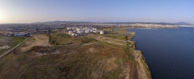 Selanik 'in batı kıyı şeridi ve Kalochori lagününün havadan görünüşü, kentsel yapılar, sanayi limanı ve sakin sulak arazi manzarasının harmanlanması.