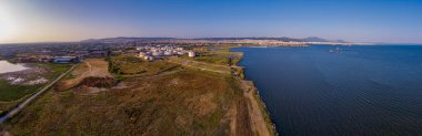 Selanik 'in batı kıyı şeridi ve Kalochori lagününün havadan görünüşü, kentsel yapılar, sanayi limanı ve sakin sulak arazi manzarasının harmanlanması.