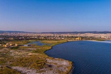 Selanik 'in batı kıyı şeridi ve Kalochori lagününün havadan görünüşü, kentsel yapılar, sanayi limanı ve sakin sulak arazi manzarasının harmanlanması.