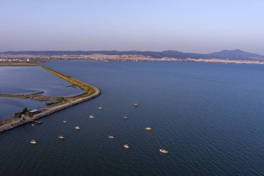 Selanik 'in batı kıyı şeridi ve Kalochori lagününün havadan görünüşü, kentsel yapılar, sanayi limanı ve sakin sulak arazi manzarasının harmanlanması.