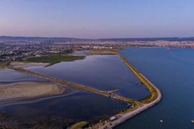 Selanik 'in batı kıyı şeridi ve Kalochori lagününün havadan görünüşü, kentsel yapılar, sanayi limanı ve sakin sulak arazi manzarasının harmanlanması.