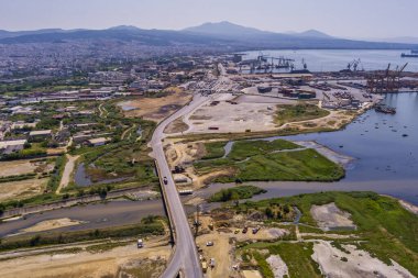 Selanik 'in batı kıyı şeridi ve Kalochori lagününün havadan görünüşü, kentsel yapılar, sanayi limanı ve sakin sulak arazi manzarasının harmanlanması.