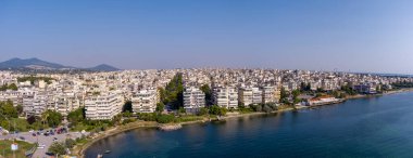 Selanik 'in batı kıyı şeridi ve Kalochori lagününün havadan görünüşü, kentsel yapılar, sanayi limanı ve sakin sulak arazi manzarasının harmanlanması.