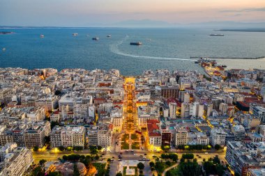 Selanik, Yunanistan 3 Ağustos 2025 - Aristo Meydanı 'nın panoramik hava manzarası liman kenti, şehir merkezi ve Termaik Körfez sularıyla altın saatinde aydınlandı