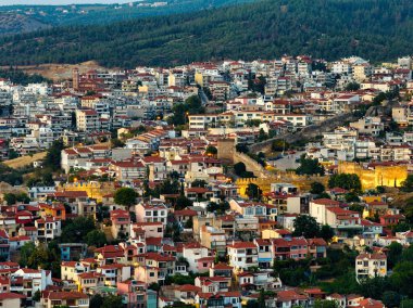 Selanik, Yunanistan 3 Ağustos 2025 - Ortaçağ kalesi, geleneksel kırmızı çatılı evler ve tepenin üzerinde altın gün batımı ışıklarının yer aldığı tarihi Selanik kentinin panoramik hava manzarası