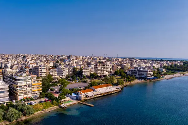 Yunanistan 'ın doğusundaki Selanik' in hava manzarası, açık mavi gökyüzü altında kıyı kentsel mimarisi, deniz ufku ve sakin şehir manzarası sergileniyor