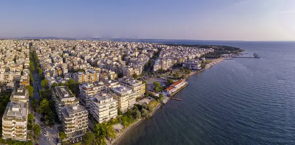 Yunanistan 'ın doğusundaki Selanik' in hava manzarası, açık mavi gökyüzü altında kıyı kentsel mimarisi, deniz ufku ve sakin şehir manzarası sergileniyor
