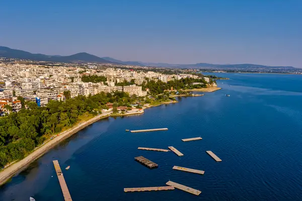 Selanik 'in batı kıyı şeridi ve Kalochori lagününün havadan görünüşü, kentsel yapılar, sanayi limanı ve sakin sulak arazi manzarasının harmanlanması.
