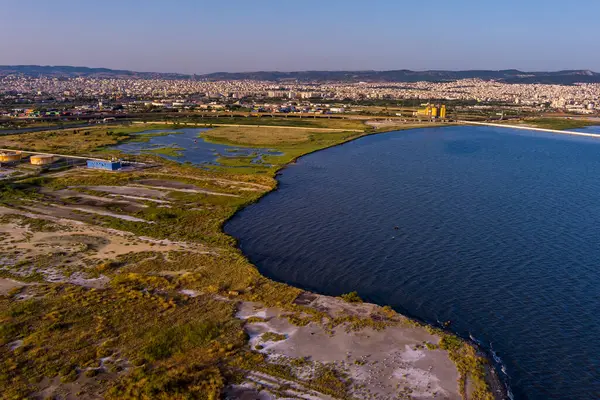 Selanik 'in batı kıyı şeridi ve Kalochori lagününün havadan görünüşü, kentsel yapılar, sanayi limanı ve sakin sulak arazi manzarasının harmanlanması.