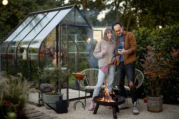 Genç Çift Telefonda Fotoğraf Çektirirken Arka Bahçedeki Güzel Bahçedeki Şöminenin — Stok fotoğraf