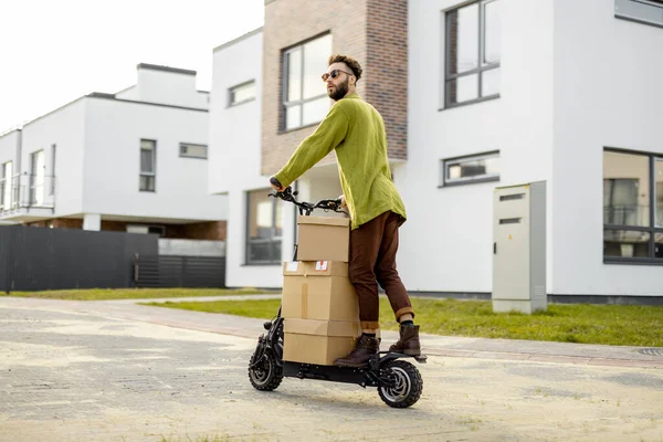 Mann Fährt Elektroroller Liefert Kartons Auf Straße Wohngebiet Aus Konzept — Stockfoto