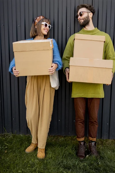 这对年轻貌美 时尚的夫妇站在户外 手里拿着硬纸板包裹 送货及网上购物的概念 — 图库照片