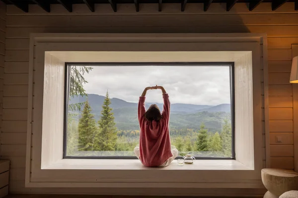Kadın Pencere Pervazında Otururken Meditasyon Yapıyor Dağlarda Panoramik Manzaranın Tadını — Stok fotoğraf