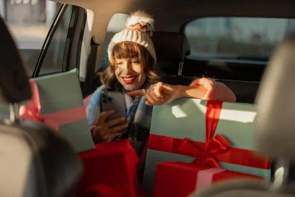 Młoda Kobieta Ubrana Święta Jeździ Samochodem Tylnym Siedzeniu Pięknie Zapakowanymi — Zdjęcie stockowe