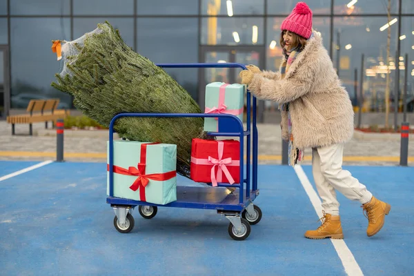 Woman Pushing Shopping Trolley Full Presents Christmas Tree Front Mall — Stock Photo, Image