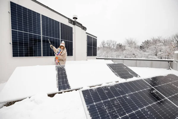 Kobieta Czyści Panele Słoneczne Śniegu Aby Zimą Wytwarzać Energię Dachu — Zdjęcie stockowe