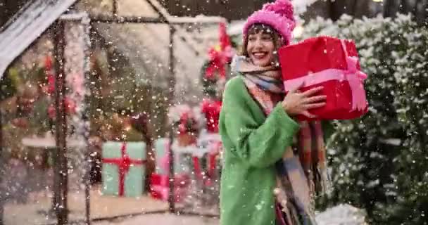 休日を見越して若い女性が開催され 雪の上に美しく装飾された庭でギフトボックスを振る 幸せな冬の休日と魔法の概念 — ストック動画