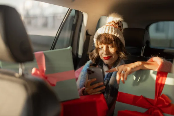 Młoda Kobieta Ubrana Święta Jeździ Samochodem Tylnym Siedzeniu Pięknie Zapakowanymi — Zdjęcie stockowe