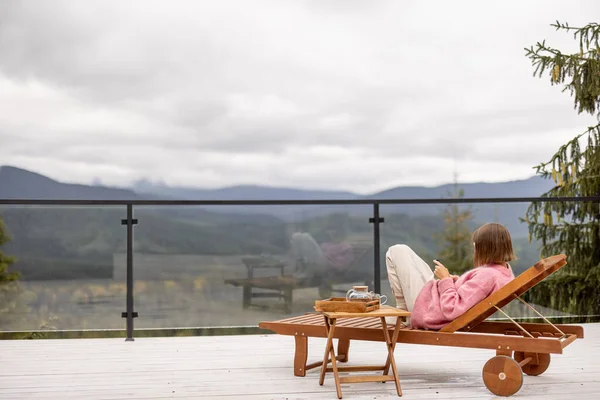 Wanita Bersweater Pink Bersandar Teras Putih Yang Luas Pegunungan Rekreasi — Stok Foto
