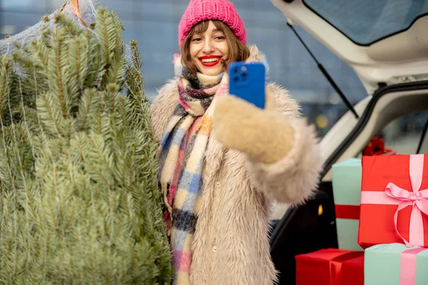 年轻快乐的女人一边站在圣诞树旁一边打电话 一边在户外购物中心附近送礼 节日气氛和零售概念 — 图库照片