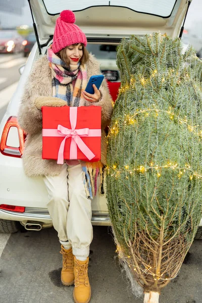 센터에서 휴가를 보내기 쇼핑중에 핸드폰을 사용하는 크리스마스 트리를 직전에 상자에 — 스톡 사진
