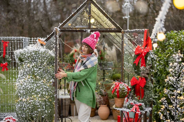 若い女性は新年の花輪で温室を飾り 裏庭での冬の休暇の準備をしています お祝いの気分や装飾の概念 — ストック写真