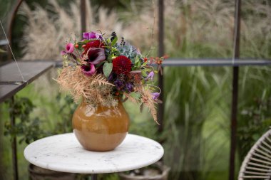 Güzel, yemyeşil bir çiçek buketi, açık havada, vazoda.