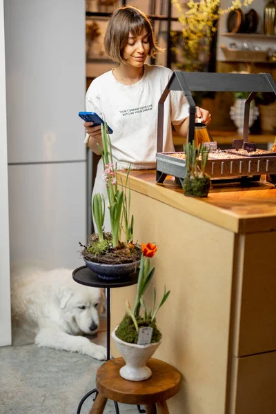 Young Woman Growing Sprouts Artificial Light Standing Kitchen Flowers Home — 图库照片