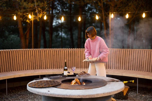 Young Woman Prepares Food Beautiful Outdoor Lounge Area Fire Bench — 图库照片