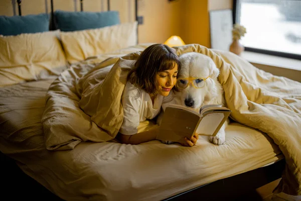 Jonge Vrouw Met Haar Schattige Hond Bril Die Een Boek — Stockfoto