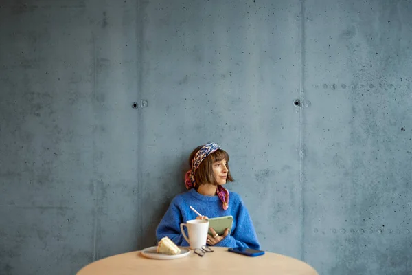 Young Stylish Woman Works Digital Tablet While Sitting Blue Concrete — kuvapankkivalokuva