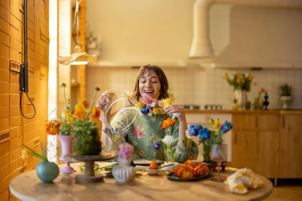 年轻的女人在餐桌边享用着一餐 桌上摆满了花瓶和盘子里的不同花朵 美与花卉饮食的概念 — 图库照片