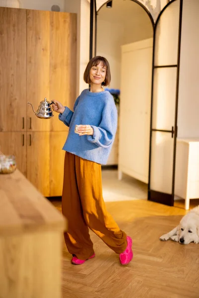 年轻女人在其现代工作室公寓的厨房里带着水壶和杯子散步 度过了一段闲暇时光 家庭生活方式和健康概念 — 图库照片