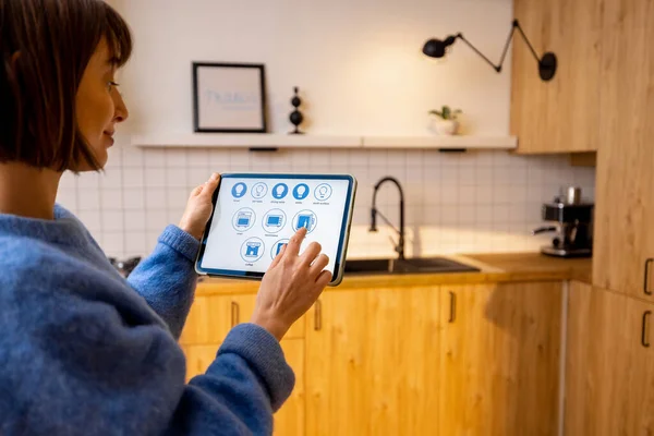 女性はスマートキッチン家電を制御し スマートホームプログラムを実行してデジタルタブレットを保持しています 快適生活のための新技術の概念 — ストック写真