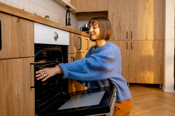 Mulher Abre Forno Enquanto Cozinha Casa Conceito Equipamentos Cozinha Modernos — Fotografia de Stock