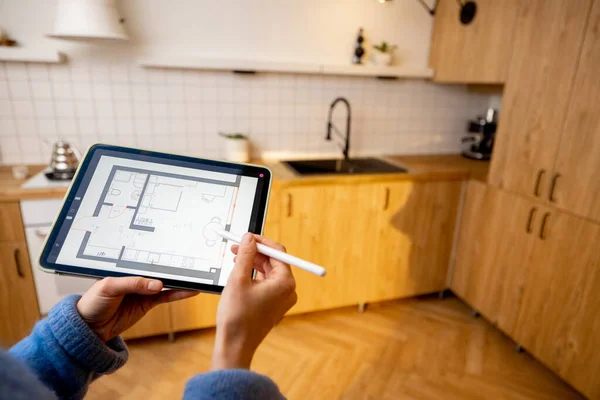 stock image Woman holding touchpad with running program of architectural project, designing kitchen space. Concept of interior design and modern technologies