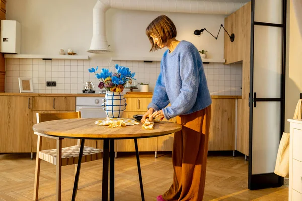 女人坐在餐桌前 在时尚的工作室公寓里做一些家务活 家庭舒适和生活方式的概念 — 图库照片