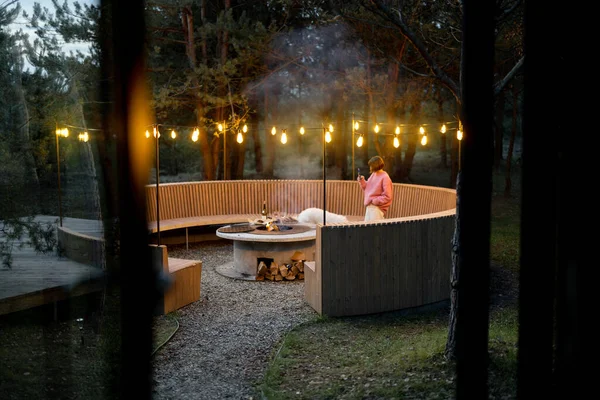 Beautiful Lounge Area Bench Bonfire Illuminated Garlands House Pine Forest — Stok fotoğraf