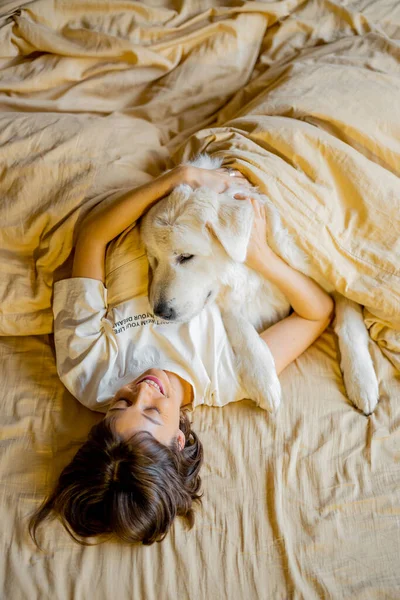 Young Woman Hugs Her Cute Dog While Lying Together Covered — 스톡 사진