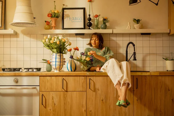 Søt Avslappet Kvinne Sitter Kjøkkenvasken Moderne Kjøkkeninteriør Dekorert Med Friske – stockfoto